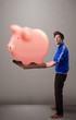 Handsome man holding a huge savings piggy bank