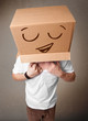 Young man gesturing with a cardboard box on his head with smiley