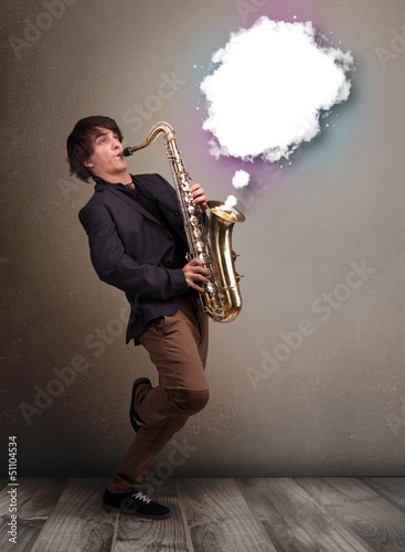 Photo: Young man playing on saxophone with copy space in white cloud Young man playing on saxophone with copy space in white cloud