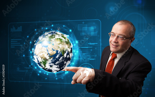 Photo: Businessman touching high-tech 3d earth panel Businessman touching high-tech 3d earth panel
