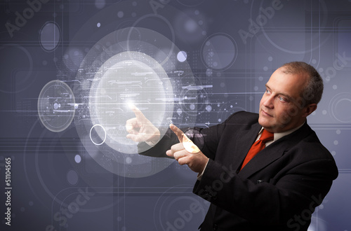 Photo: Businessman touching abstract high technology circular buttons Businessman touching abstract high technology circular buttons