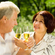 Senior couple celebrating with champagne, outdoors
