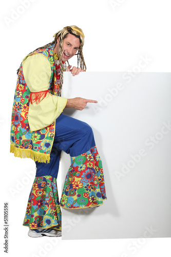Photo: Man wearing hippy costume pointing at blank message board Man wearing hippy costume pointing at blank message board
