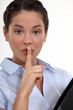 Businesswoman with her finger to her lips