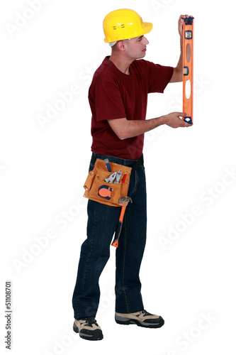 Photo: Worker checking a spirit level Worker checking a spirit level