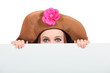 Woman hiding wearing a big brown hat
