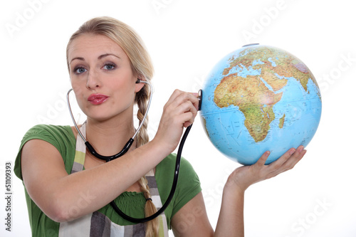 Photo: HOLDING, STETHOSCOPE ON GLOBE HOLDING, STETHOSCOPE ON GLOBE