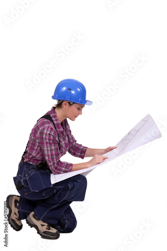 Photo: Female builder looking at architect plans Female builder looking at architect plans