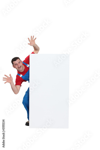 Photo: Scary builder jumping out from behind poster Scary builder jumping out from behind poster