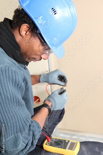 Photo: Electrician using voltmeter Electrician using voltmeter
