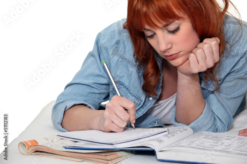Photo: Young woman completing her homework Young woman completing her homework