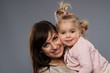 Happy smiling young mother hugs her little daughter