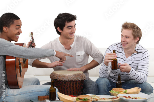 Photo: Three male friends playing instruments Three male friends playing instruments