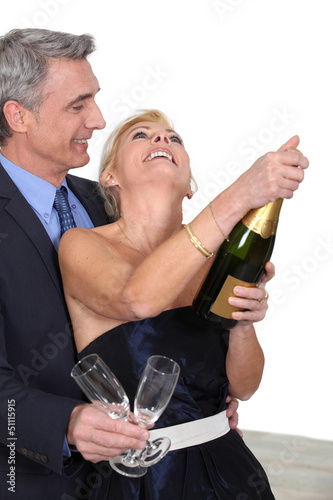 Photo: mature couple celebrating with champagne mature couple celebrating with champagne