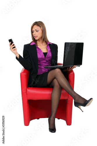 Photo: Woman sat with mobile telephone and computer Woman sat with mobile telephone and computer