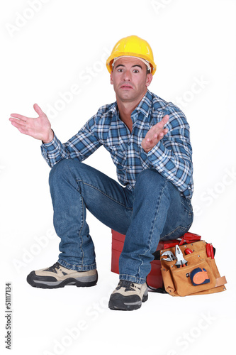 Photo: craftsman sitting on his toolbox and gesturing craftsman sitting on his toolbox and gesturing