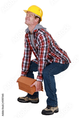 Photo: Tradesman lifting a heavy load Tradesman lifting a heavy load