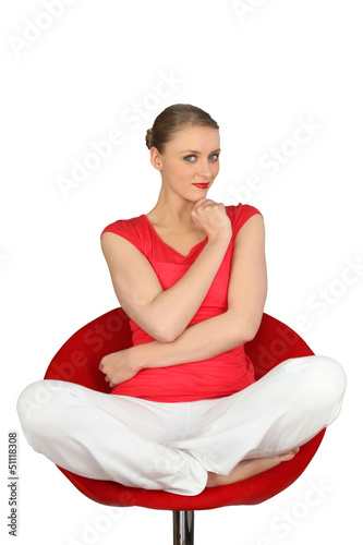 Photo: Pensive blond sat cross-legged on swivel chair Pensive blond sat cross-legged on swivel chair