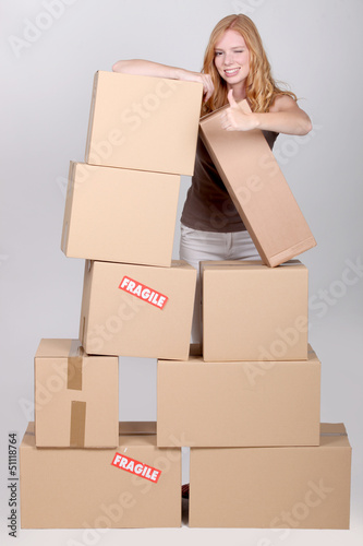 Photo: Woman stood by pile of cardboard boxes Woman stood by pile of cardboard boxes