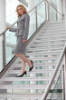 Foto: Businesswoman walking down steps Businesswoman walking down steps