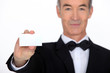 Silver service waiter holding up a business card