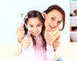 Mother and daughter brush their teeth.