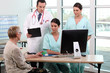 Doctor, patient, and medical secretaries at reception