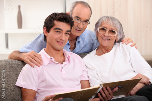 Photo: Family looking at photo album Family looking at photo album