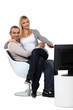 Couple sitting in a chair watching television