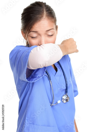 Photo: Sneezing woman medical nurse doing elbow sneeze Sneezing woman medical nurse doing elbow sneeze