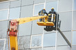 workers installing glass window on building