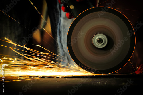 Photo: Worker cutting metal with grinder Worker cutting metal with grinder