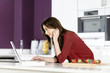 Woman in kitchen reading recipe