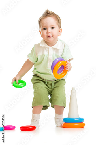 Photo: Cute little boy playing colorful toys isolated on white Cute little boy playing colorful toys isolated on white
