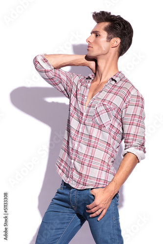 Photo: man poses with hand on neck man poses with hand on neck
