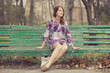 Style redhead girl sitting on the bench
