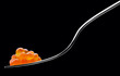 Photo: The fork with red caviar on a black background The fork with red caviar on a black background