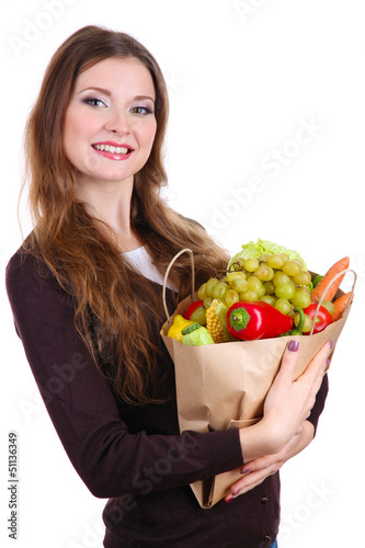 Photo: Woman holding a grocery bag full of fresh vegetables and fruits Woman holding a grocery bag full of fresh vegetables and fruits