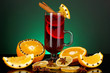 Fragrant mulled wine in glass with spices and oranges around