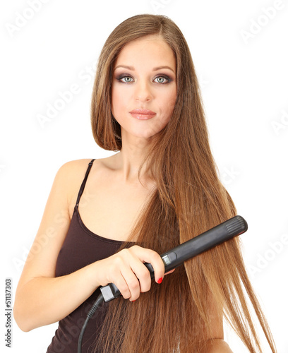 Photo: Woman doing hairstyle with hair straightener, isolated on white Woman doing hairstyle with hair straightener, isolated on white