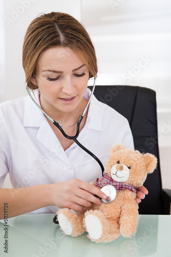 Photo: Female Doctor Examining Teddy Bear Female Doctor Examining Teddy Bear