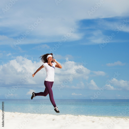 Photo: Young woman running on the beach Young woman running on the beach