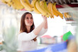 Young woman buying bananas at the market