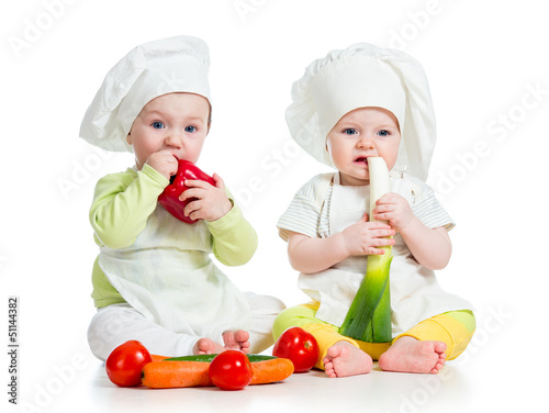 Photo: babies boy and girl wearing a chef hat with healthy food vegeta babies boy and girl wearing a chef hat with healthy food vegeta