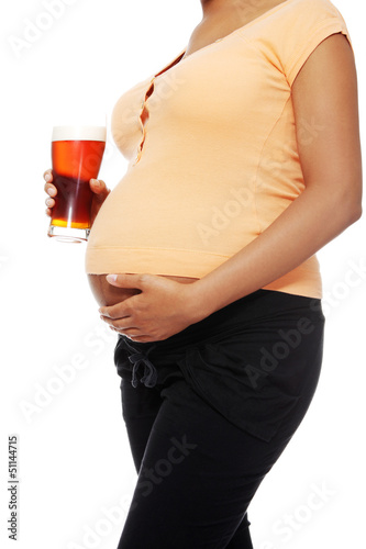 Photo: Pregnant woman holding a glass of alcohol next to her tummy Pregnant woman holding a glass of alcohol next to her tummy