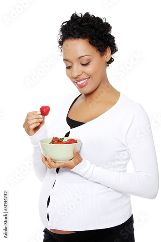 Photo: Portrait of a beautifyl young woman eating strawberries Portrait of a beautifyl young woman eating strawberries