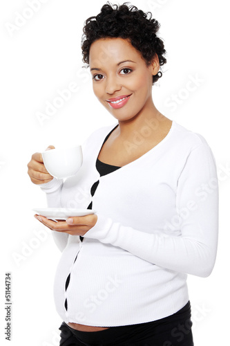 Photo: Young pregnant woman drinks cafe or tea Young pregnant woman drinks cafe or tea