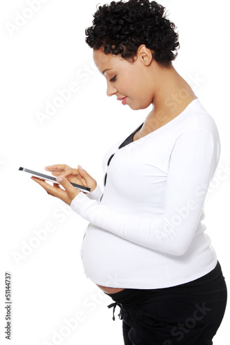 Photo: Pregnant woman relaxing with a computer tablet Pregnant woman relaxing with a computer tablet