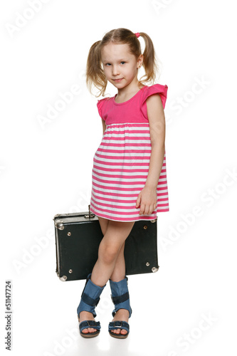 Photo: Little girl with old fashioned suitcase in full length Little girl with old fashioned suitcase in full length