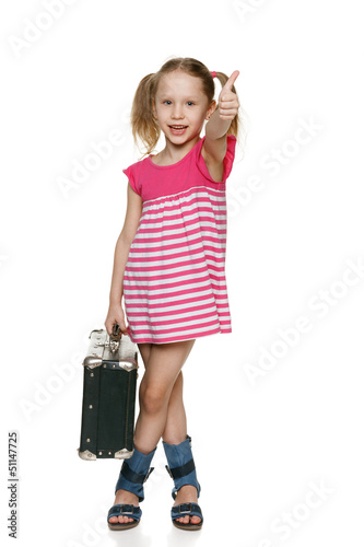 Photo: Little girl with old fashioned suitcase showing thumb up Little girl with old fashioned suitcase showing thumb up